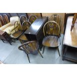 A set of seven Ercol dark elm and beech chairs and a beech drop leaf table