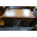 A mahogany and brown leather topped pedestal desk