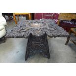 An oriental carved softwood occasional table