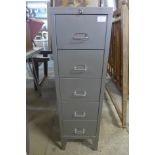 A grey five drawer metal cabinet