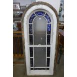 A large Arts and Crafts stained glass arch window