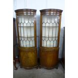 A pair of George III style mahogany astragal glazed bow front freestanding corner cabinets