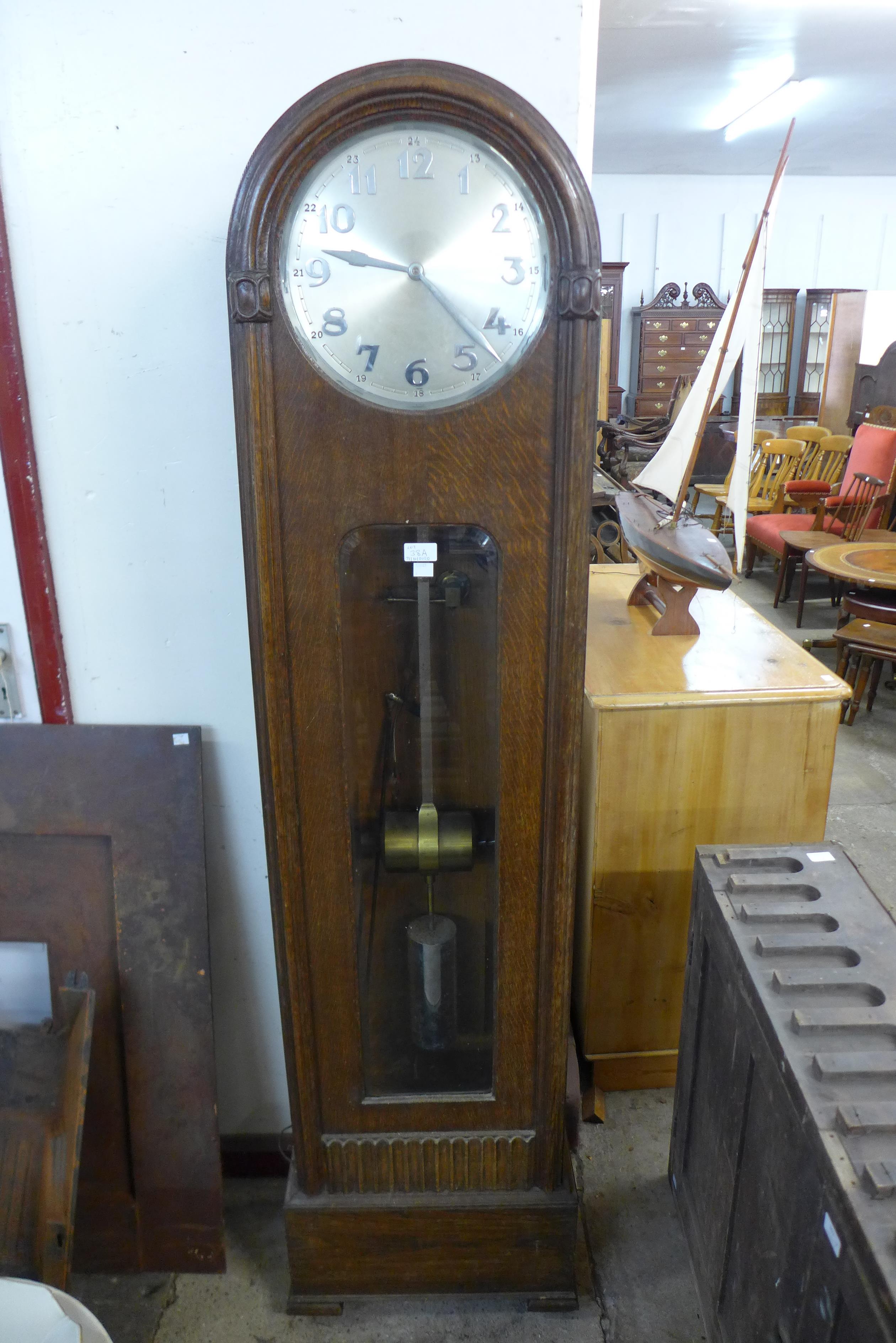 An early 20th Century oak electric longcase clock