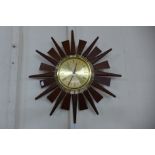 A teak and brass sunburst wall clock