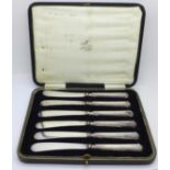 A set of six silver handled butter knives, cased