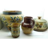 A Doulton Lambeth jardiniere, two relief moulded jugs and a saltglaze cheese dish and cover,