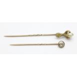 A diamond pin set in yellow metal (tests as gold) and a pearl set claw pin