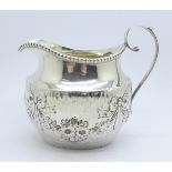 An Edwardian hammered silver cream jug decorated with swags, Birmingham 1904, Thomas Hayes, 68g