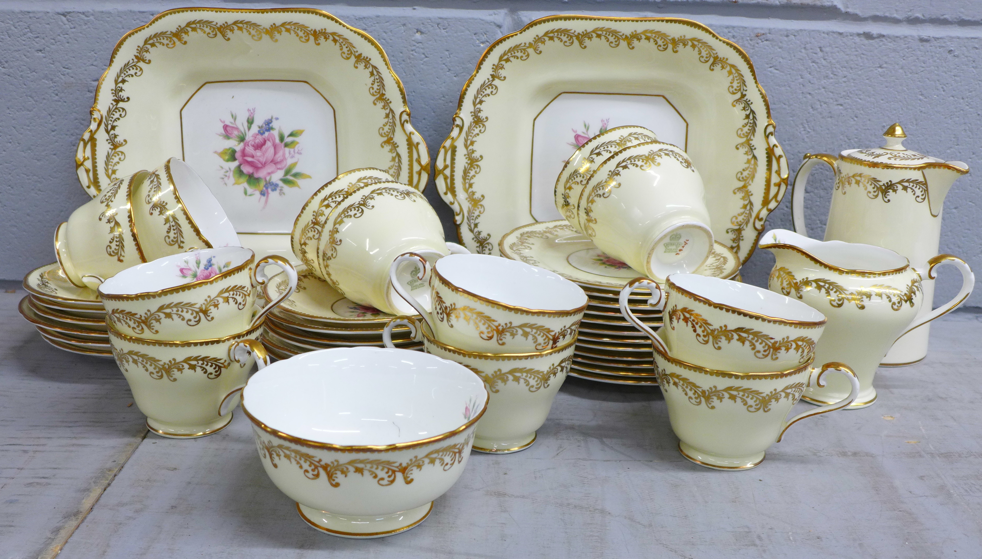 An Aynsley floral cream and gilt twelve setting tea set with hot water pot