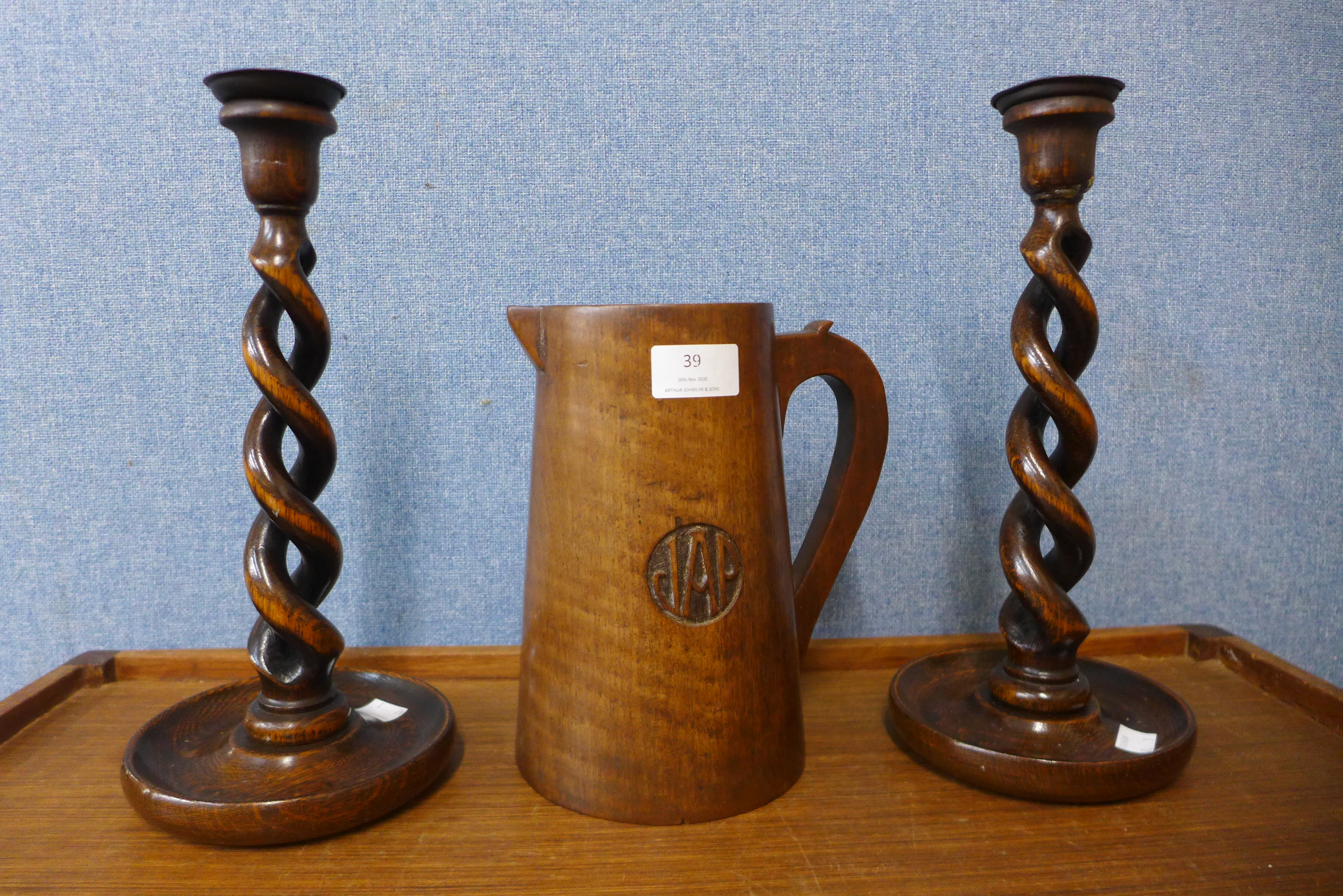 A pair of oak barleytwist candlesticks, 31cms and a treen jug