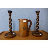 A pair of oak barleytwist candlesticks, 31cms and a treen jug