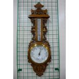 An early 20th Century carved oak aneroid barometer, 88cms h