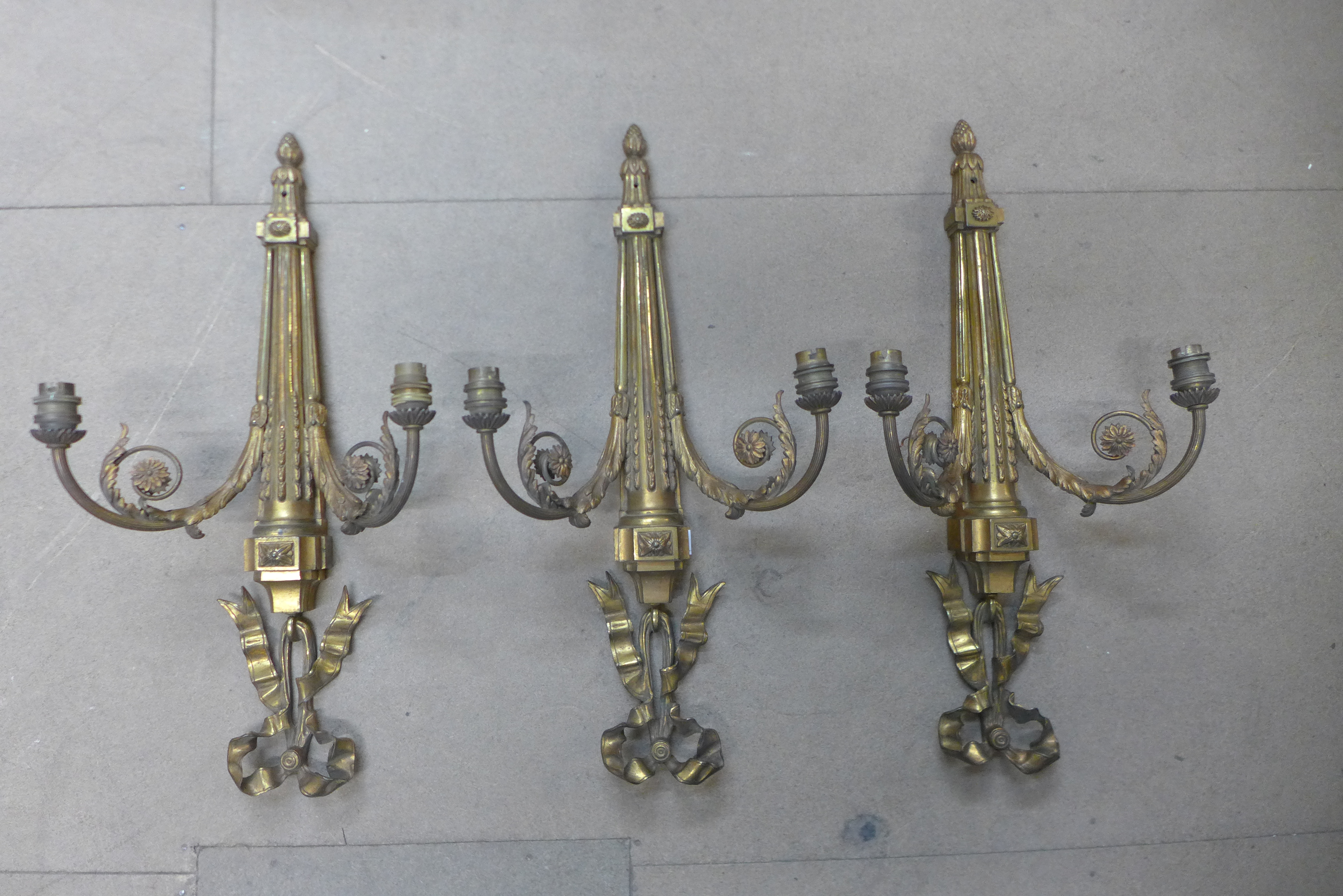 A set of three French Neo-Classical style ormolu electric wall sconces, 59cms h