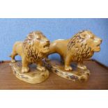 A pair of Staffordshire pottery lions, impressed mark to base; Made In England, 822, 21cms h