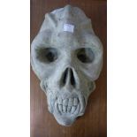 A concrete primate skull garden ornament