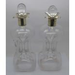 A pair of late Victorian silver rimmed pinched glass decanters, London 1899, a/f