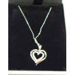 A 9ct white gold and diamond heart shaped pendant and chain, 2.3g