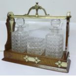 An oak framed tantalus, marked Fenton Bros., Sheffield, and Staniforth Patent, glass a/f