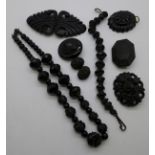 A Victorian Whitby jet bracelet, pendant and two brooches, two other carved brooches, a buckle and a