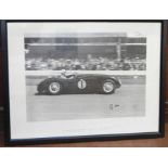 A large framed black and white print of Sir Stirling Moss in the 1953 Jaguar 'C', signed, 32.5 x