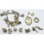 A silver charm bracelet, 87g, seven loose charms and two silver lockets