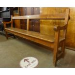 An early 20th Century pine church pew, 86cms h, 204cms w, 50cms d