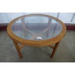 A teak and glass topped circular coffee table