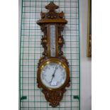 An early 20th Century carved oak aneroid barometer, 88cms h