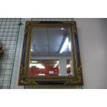 An ebonised and parcel gilt framed mirror