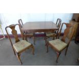A walnut draw-leaf dining table and four chairs
