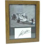 A framed photograph of John Surtees with mounted autograph
