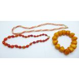 A coral and pearl necklace, one other necklace and an amber coloured bracelet