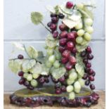 An Asian art centrepiece, jade grapes and carved soapstone vine leaves with carved wooden base, 39cm