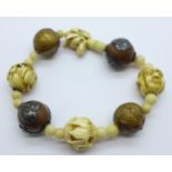 An oriental bracelet including carved ivory and metal mounted beads