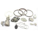Three silver bangles, three silver lockets, two brooches, a pendant, cufflinks and a rattle