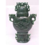 A carved green stone urn with lid, small losses to the lid and one ring missing, 23cm