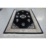 A Chinese black ground rug, 303 x 187cms