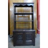 An early 20th Century Jacobean Revival carved oak open bookcase, 130cms h x 68cms w