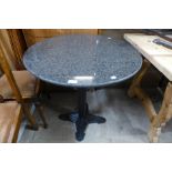 An Art Deco style cast iron and granite topped circular table