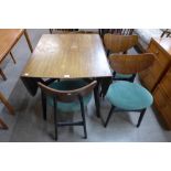A G-Plan Librenza tola wood and black lacquered drop-leaf table and four butterfly back chairs