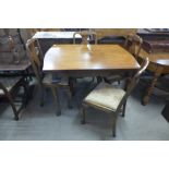 A walnut draw-leaf dining table and four chairs