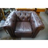 A brown faux leather Chesterfield club chair, 71cms h, 103cms w, 87cms d