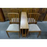 A teak drop-leaf table and four chairs