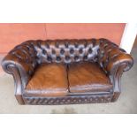A chestnut brown leather Chesterfield settee, 73cms h, 156cms w, 86cms d