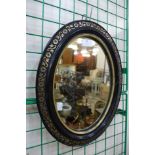 A small Victorian ebonised and parcel gilt framed oval mirror
