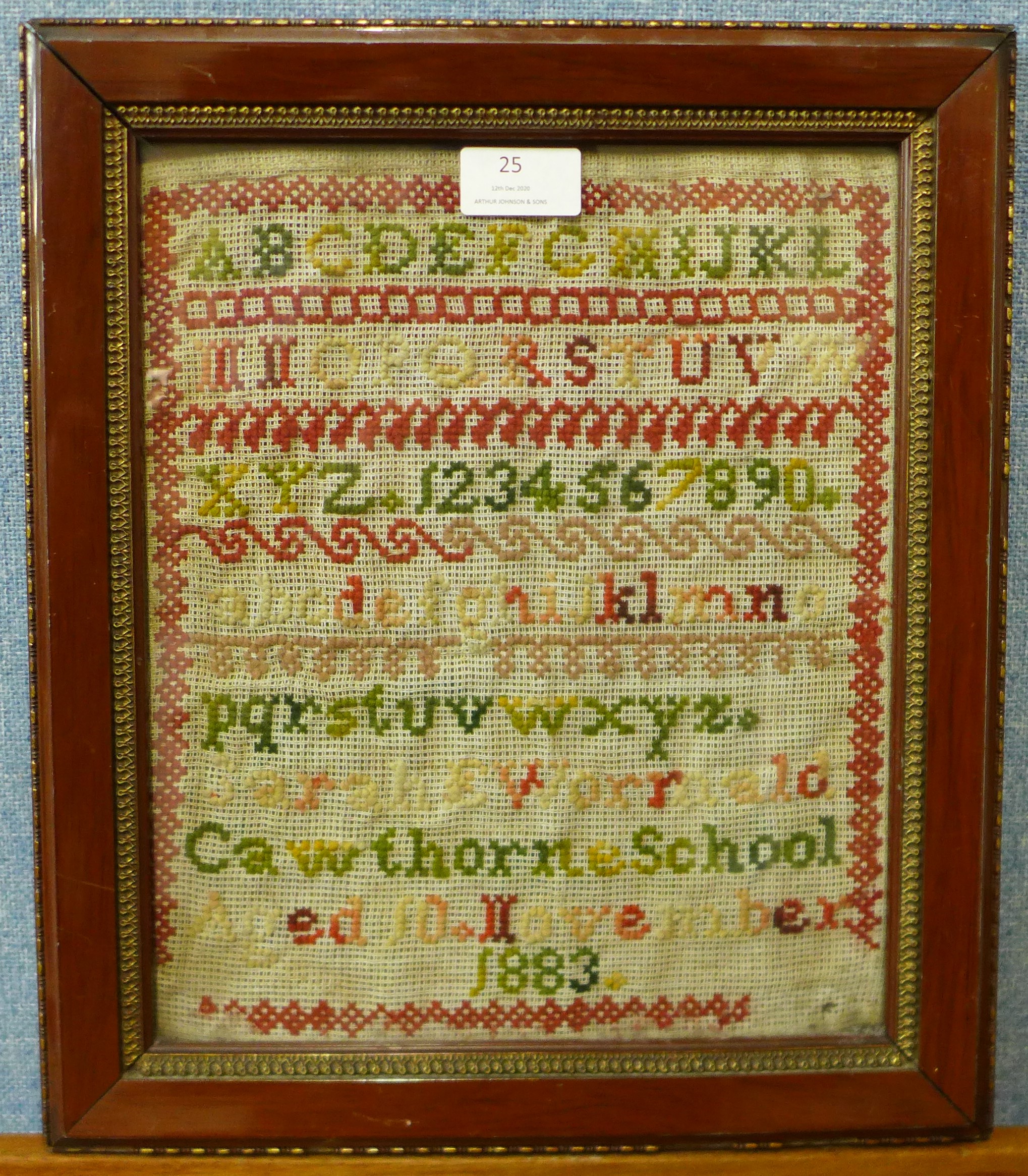 A Victorian sampler, dated 1883, 29 x 24cms, framed