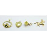 Four yellow metal pendants or charms, 3.1g