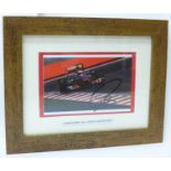 A framed photograph of a McLaren F1 car, signed by Lewis Hamilton