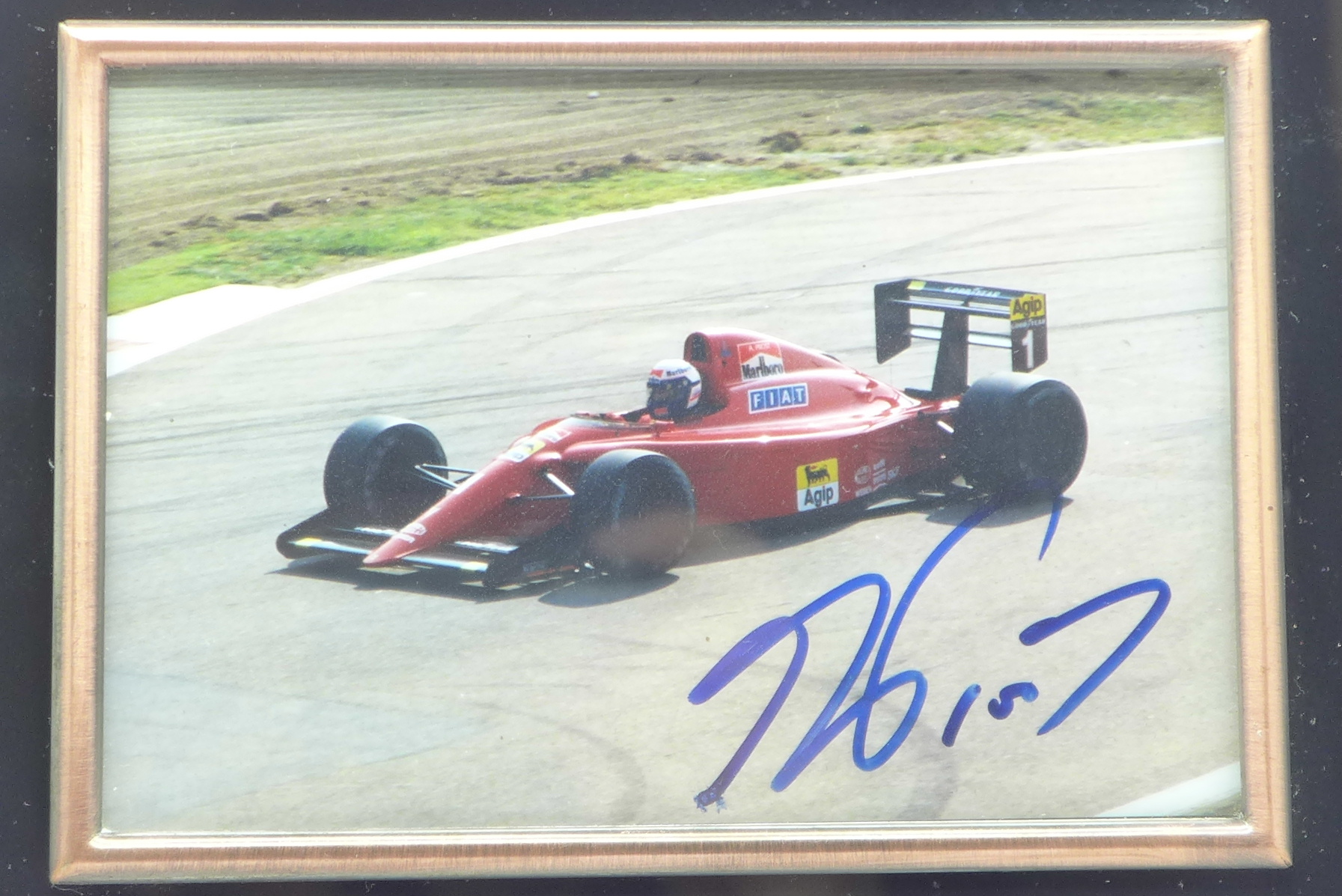 A framed photograph of a Ferrari F1 car, signed by Alain Prost