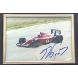 A framed photograph of a Ferrari F1 car, signed by Alain Prost